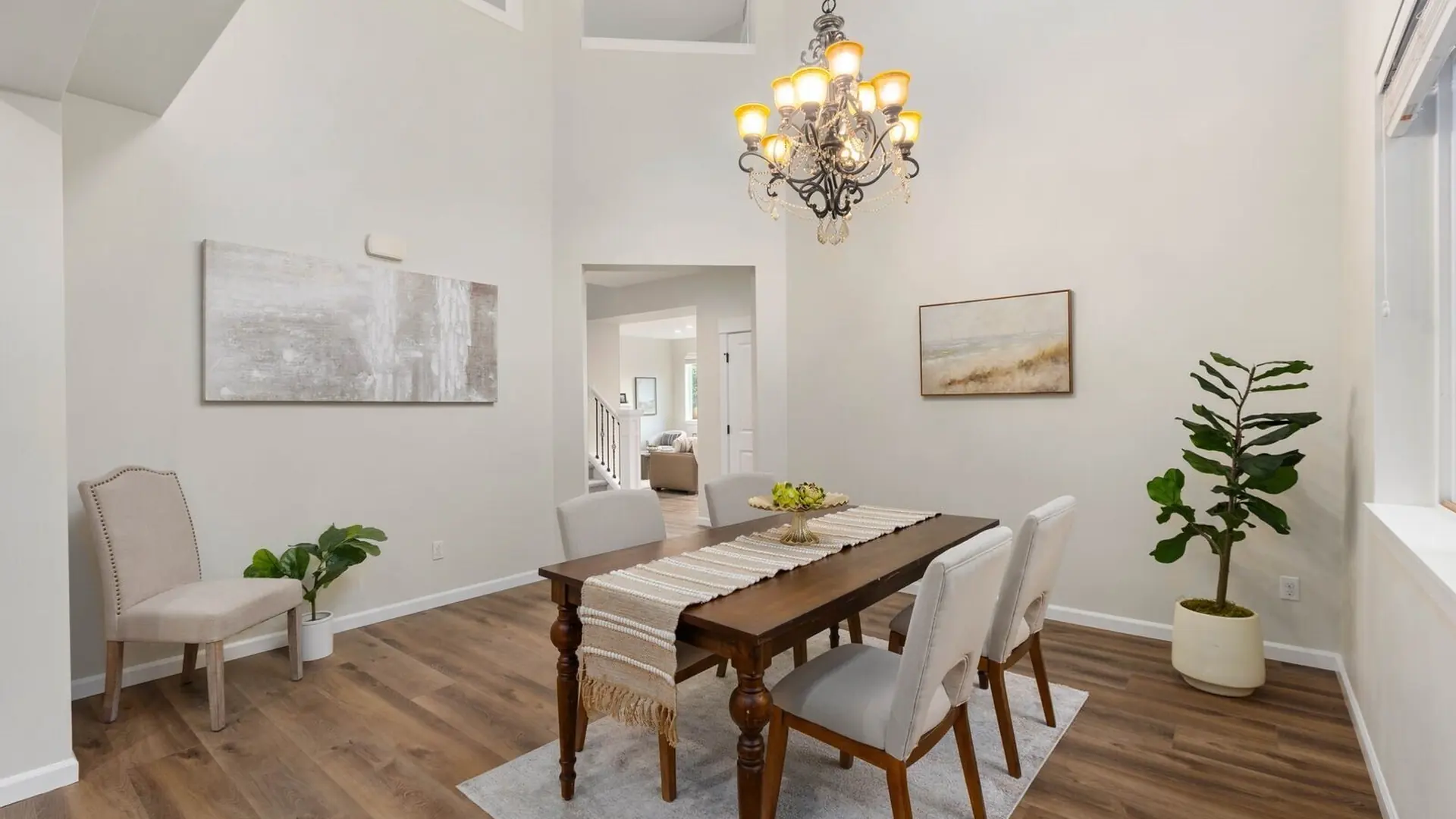 The dining room of 14008 SE 21st Place, Bellevue: a chandelier over a wooden table, windows to the trees
