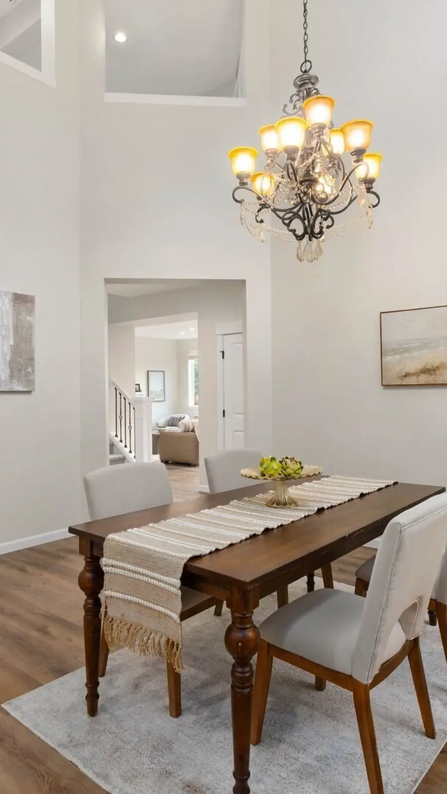 The dining room of 14008 SE 21st Place, Bellevue: a chandelier over a wooden table, windows to the trees