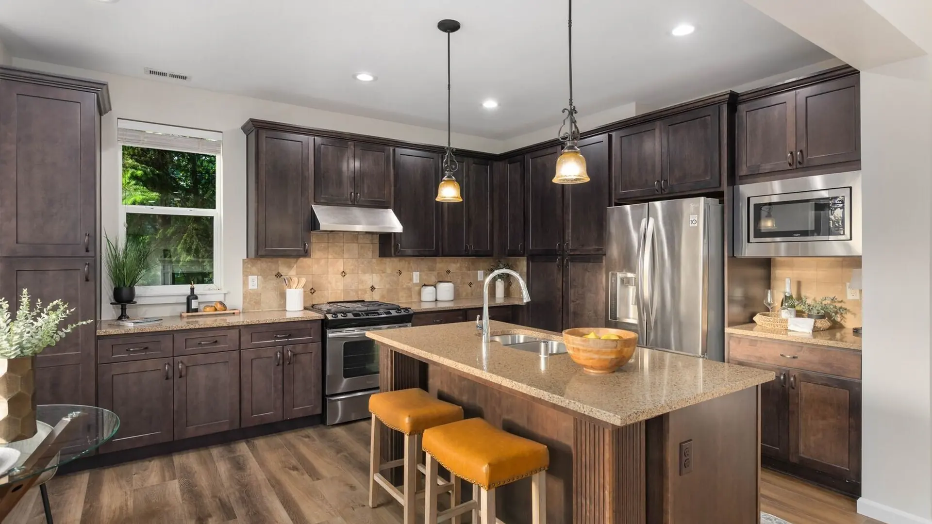 The kitchen of 14008 SE 21st Place, Bellevue: a long island with bar stools and dark cabinetry